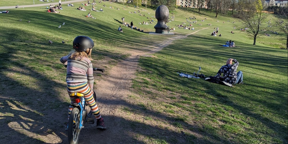 Jente sykler i park i Oslo. 