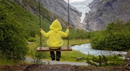Child, cute blond boy, toddler enjoying the amazing view of the glacier in Jostedalsbreen national park