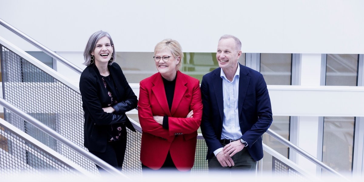 Bilde av tre personer i en trapp